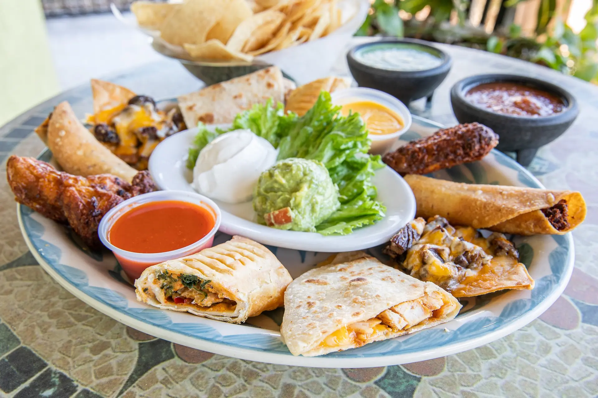 An Iguana Joe’s appetizer sampler with quesadillas, wings, taquitos, guacamole and sauces
