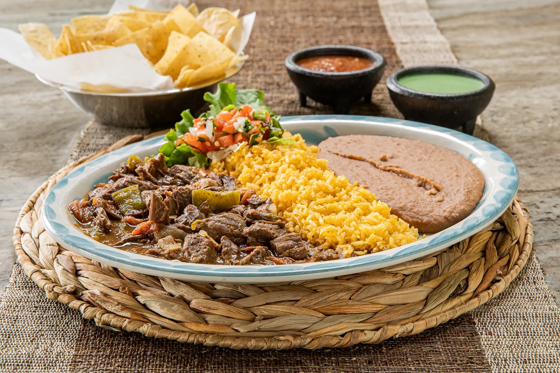 A hearty Tex-Mex plate with rice, beans, pico, chips and salsa